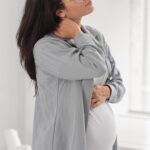 gestante com ansiedade na gestação de perfil com as mãos na barriga
