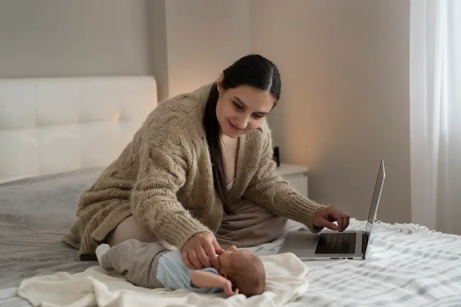 mãe com bebê ao lado fazendo sessão de terapia online pelo notebook em casa